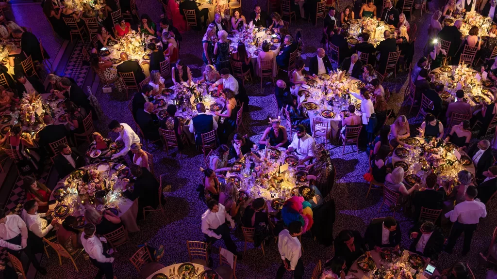 Round tables set with glassware and place settings in a banqueting room before a corporate dinner
